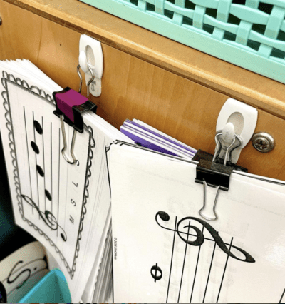 Command hooks hanging papers on the side of a desk