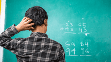 Student in front of a blackboard with math problems
