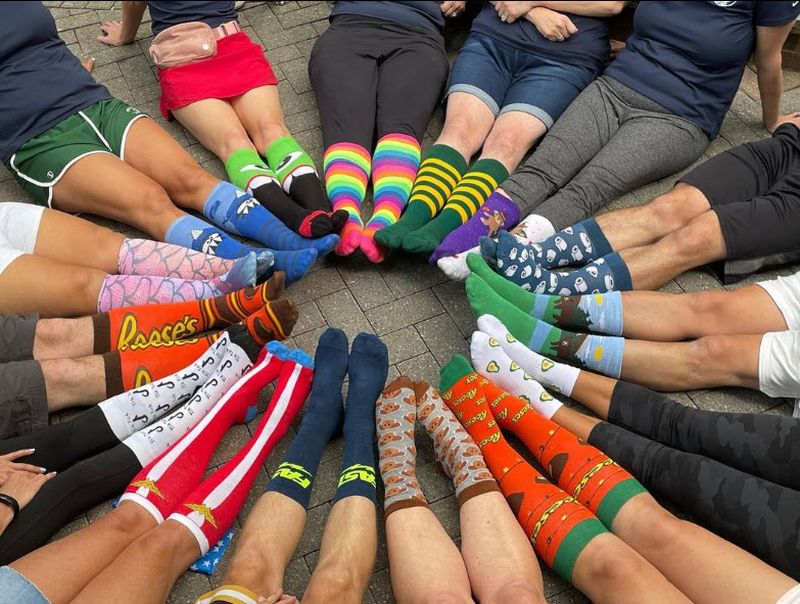 Kids sitting in a circle showing off their unique socks for crazy sock day