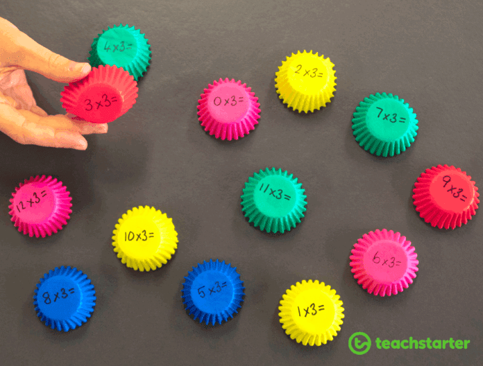 Teach multiplication using cupcake liners with multiplication problems written on them