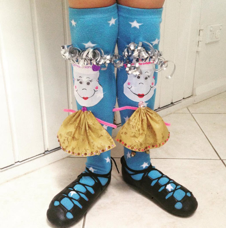 Blue socks with faces and hair made from curling ribbon, wearing little skirts
