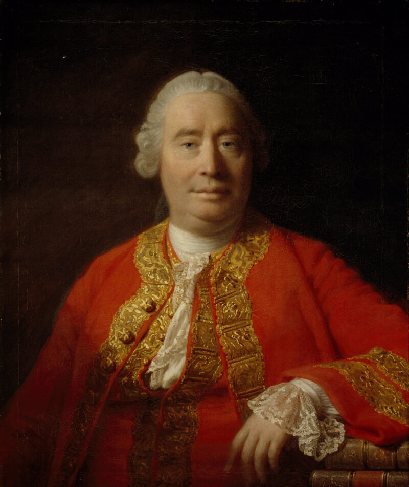 An old man is shown from the waist up wearing a regal red robe.