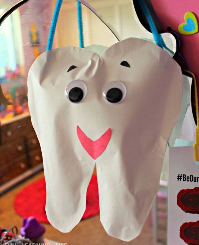 Tooth craft made from paper and stuffed with cotton balls, with googly eyes