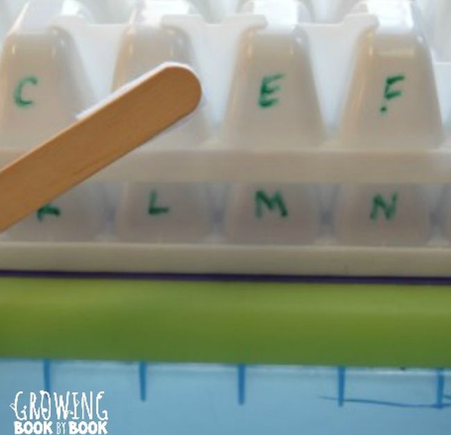 White ice cube tray turned upside down with letters written in dry erase marker 
