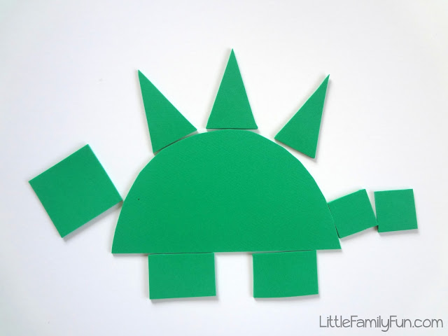 A green dinosaur is constructed from various shapes. (kindergarten art)