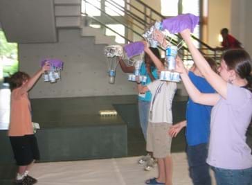 students standing to drop eggs during an egg drop challenge