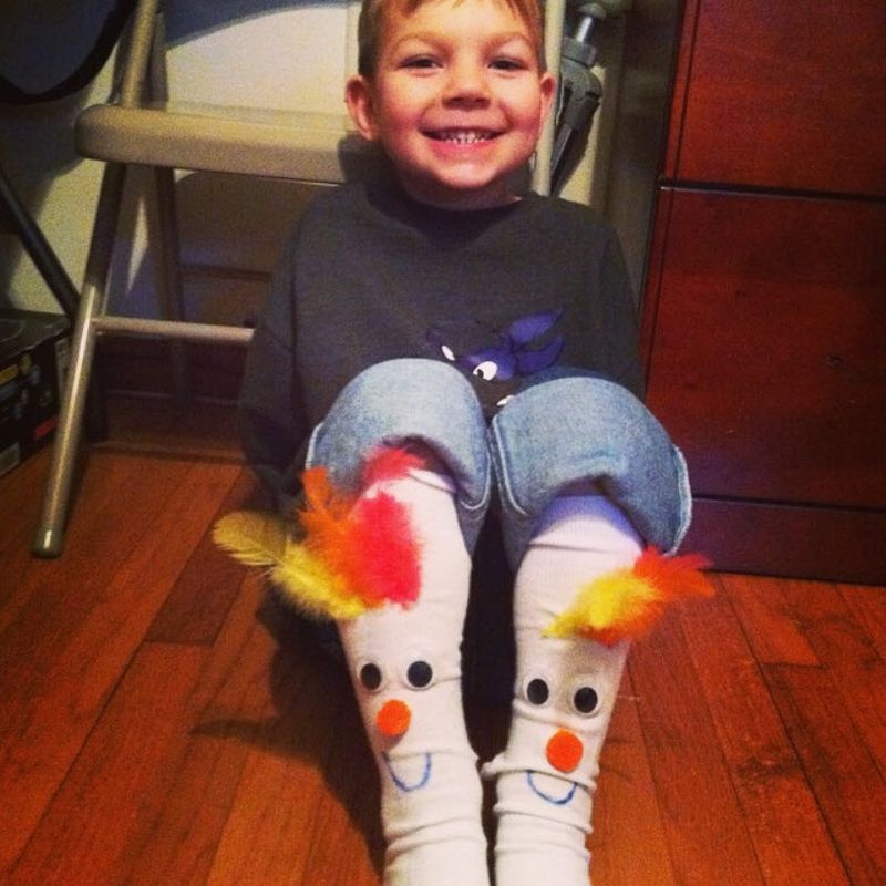 Child wearing DIY chicken socks with feathers sewn to the top