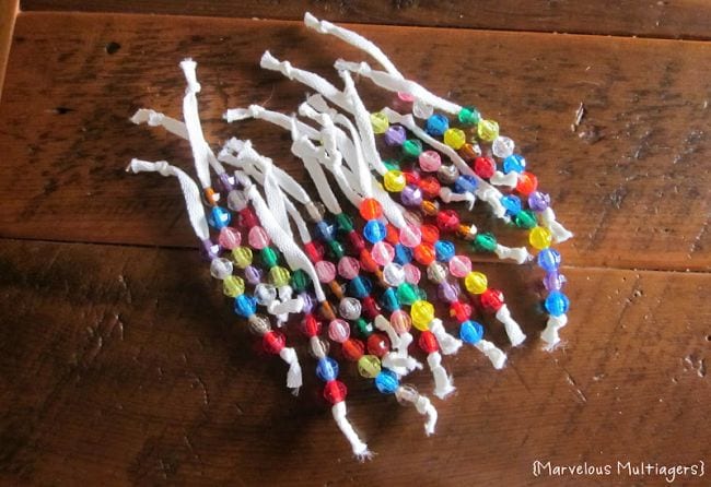 White shoelaces knotted at each end with colorful beads strung on them (DIY Fidgets)