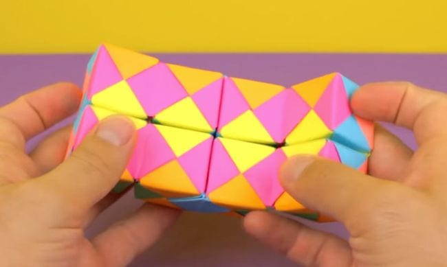 Student playing with a colorful folded paper infinity cube (DIY Fidgets)