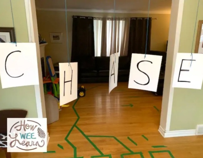 A series of letter cards hanging from a doorway spelling out the word "chase"