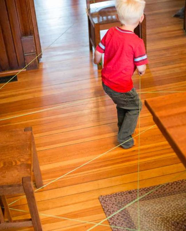 Child following a string obstacle course maze, as an example of DIY obstacle courses for kids