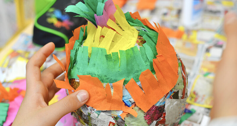 a homemade pinata made from a balloon, newspaper strips and crepe paper, as an example of cinco de mayo activities