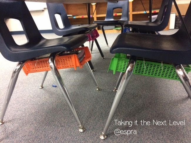 Colorful plastic paper trays attached to the bottom of school chairs 