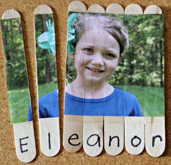 Child's picture glued to a series of wood craft sticks and cut apart, with the letters of her name underneath (Dollar Store Hacks)