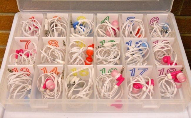 Compartmented plastic case holding numbered earbuds 