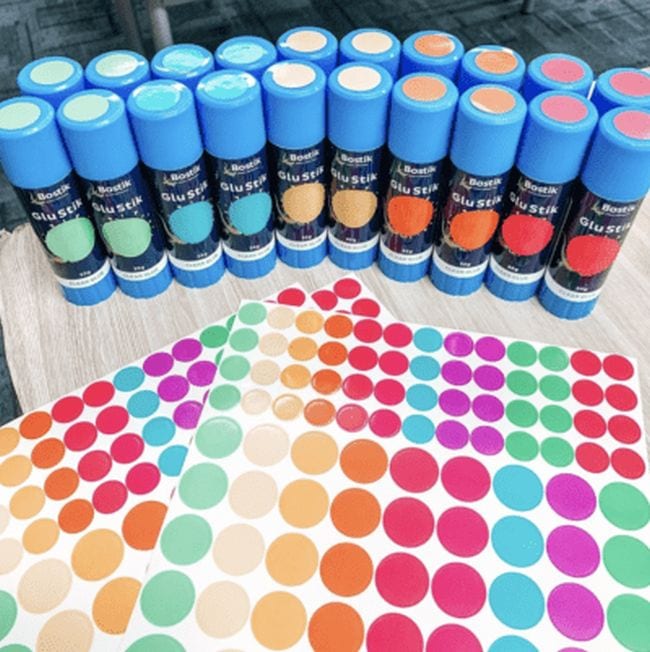 Glue sticks with colored dot stickers on the lids and bodies