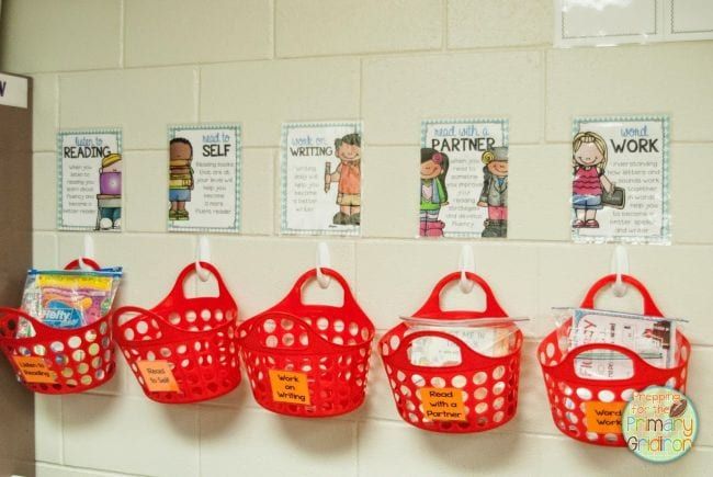 Red plastic tote baskets hung on plastic hooks on a wall (Dollar Store Hacks)
