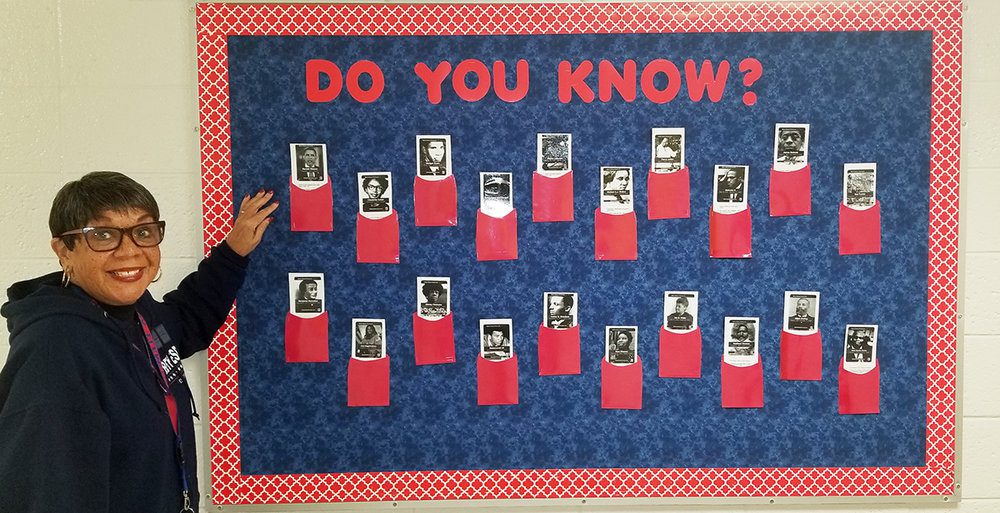 A woman stands in front of a bulletin board that says Do you know? across the top. It has photos of famous Black people on it with flaps to lift (black history month bulletin board)