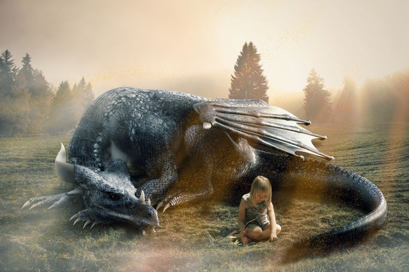 A child sitting in the grass, with a dragon curled up around her