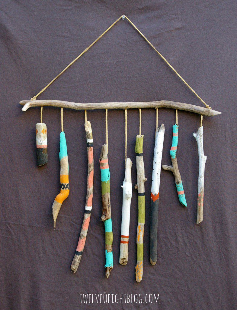 A wall hanging made from painted sticks of driftwood on a dowel