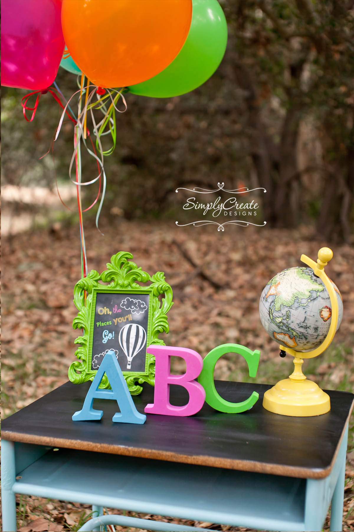 Preschool graduation ideas include party themes like this Dr. Suess one. A toy globe, a green picture frame, and three large A, B, C letters are shown.