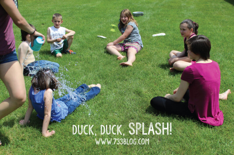 children sitting in a circle for a water game duck duck splash