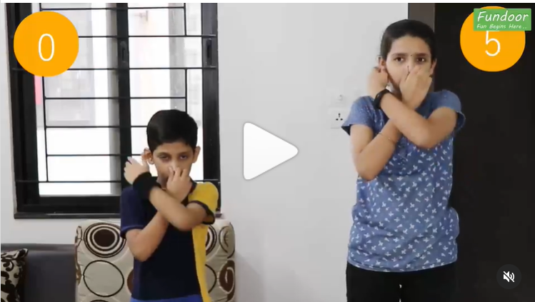 A little boy and girl stand with one finger pinching their ear and the other pinching their nose in this example of minute to win it games.