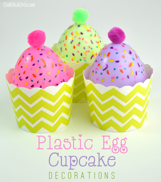 the top half of plastic eggs have been transformed into toy cupcakes. Sprinkles have been painted on them and they have pom poms for cherries. They are in cupcake wrappers.