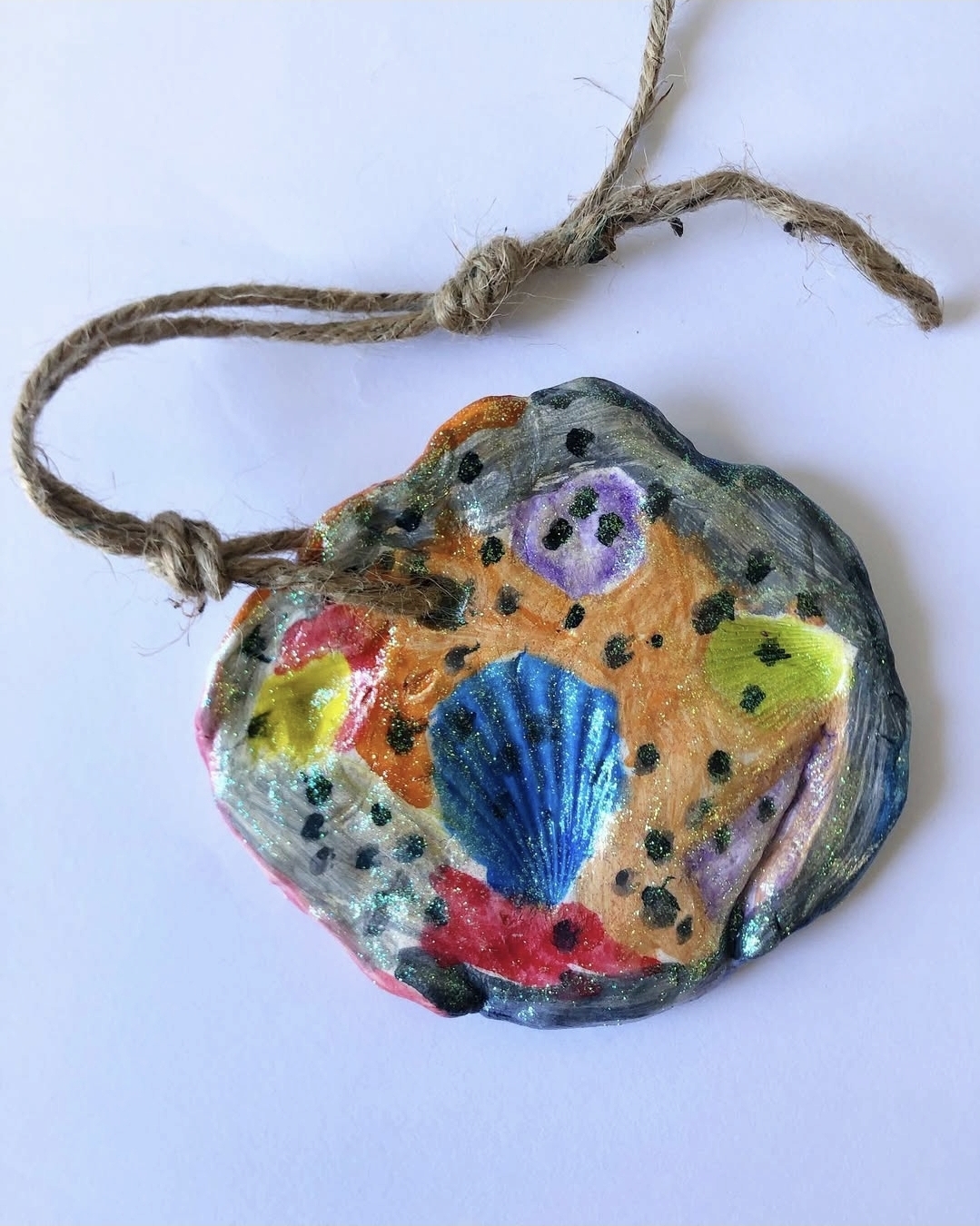 Clay ornament made by pressing shells and painting the indentations