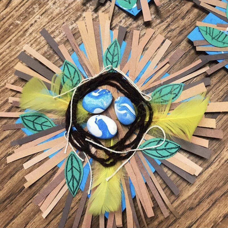 Birds nest made from paper scraps, yarn, and painted rocks