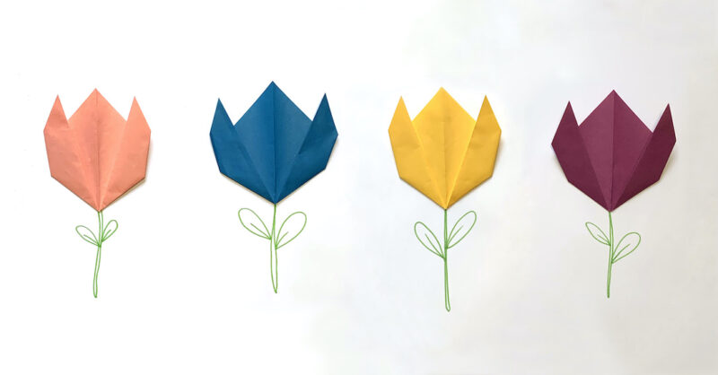 a pink, blue, yellow, and purple origami tulip is glued to white paper with a green stem drawn beneath them (spring crafts for kids)