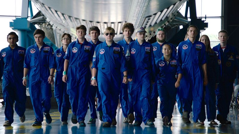 Group of young science students dressed in flight suits walking toward the camera, at space camp