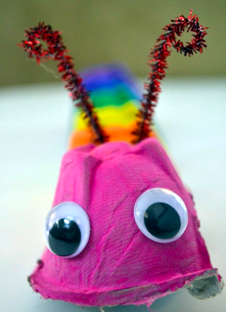 A colorful caterpillar is made from a painted section of egg carton, googly eyes and pipe cleaner antennae. 
