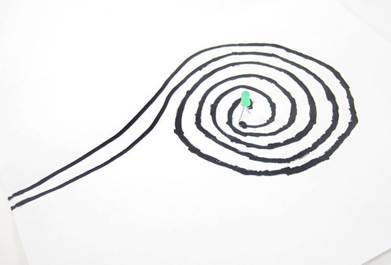 spiral of black paint on paper for electricity experiment 