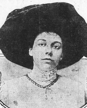 A black and white photograph of a young woman wearing a large hat is shown.