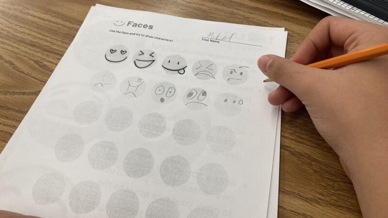 Student filling out emotion drawing worksheet