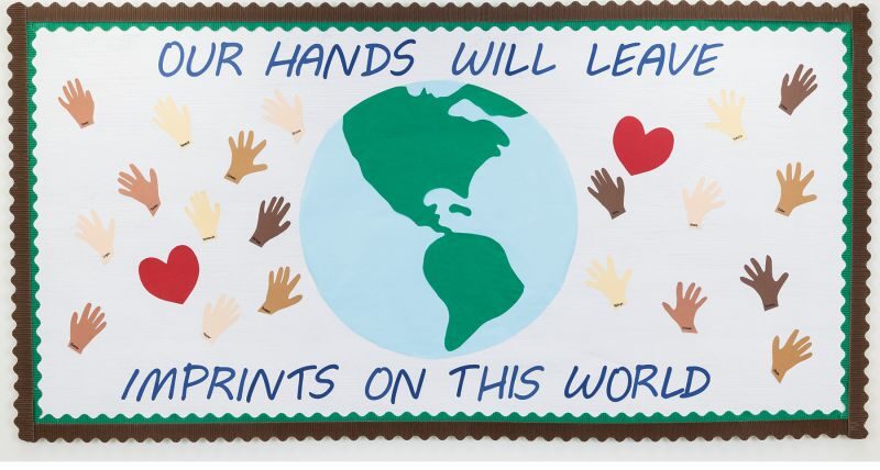 Bulletin board with globe and hands and hears that says: Our hands will leave imprints on this world.