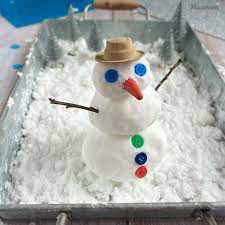 snowman in a bin of fake snow for a snow activity 