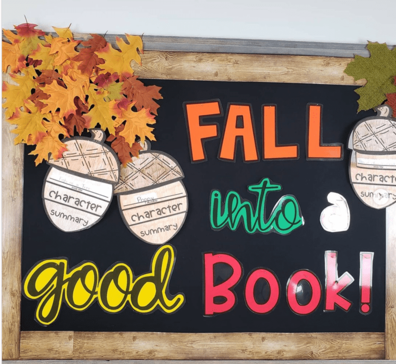 Bright colored text reads "Fall into a good book!" Large acorn cutouts say character and sumary on them and appear to be filled out by students. October bulletin boards like this one also include fake folliage.