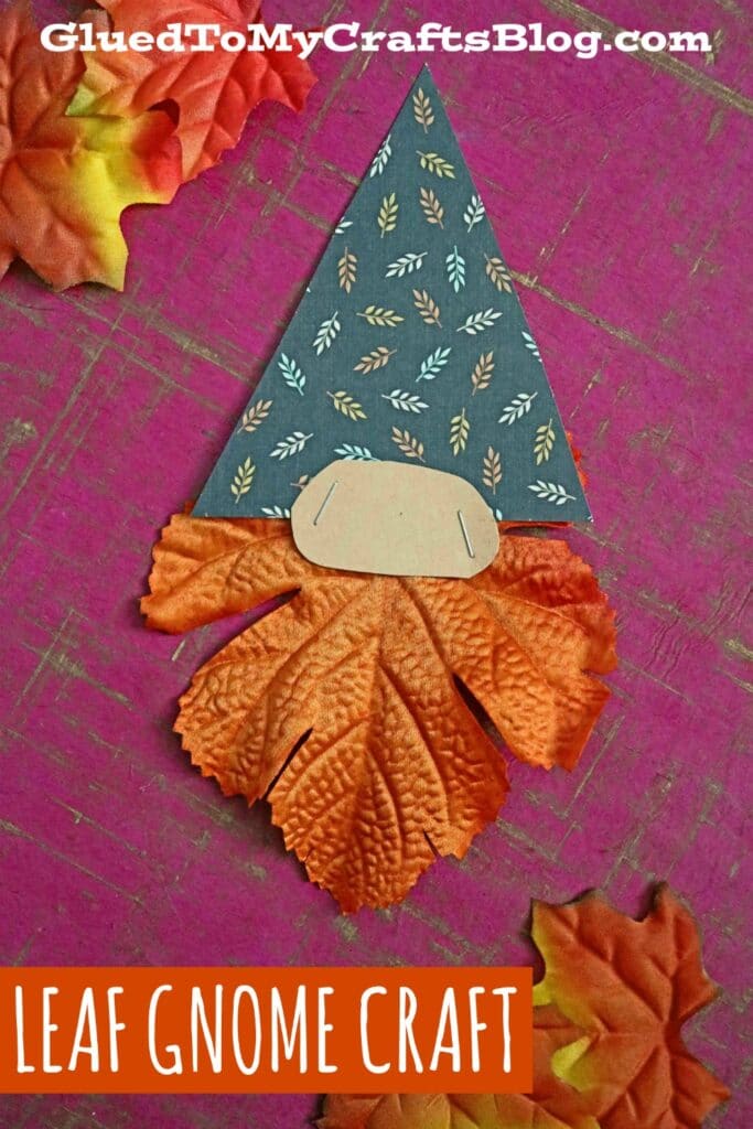 A gnome is made from scrapbook paper for a hat and a fall leaf fro the beard and a nose is stapled in between.