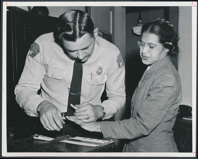 Rosa Parks being booked after being arrested,  an example of famous Black Americans everyone should know