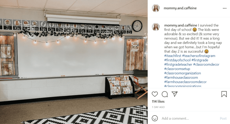 The whiteboard in a classroom with farmhouse classroom décor accents including a black and white rug, faux wood paneling, and string lights.