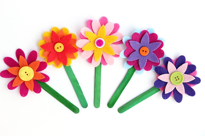 Multiple bookmarks are made from felt flowers attached to green popsicle sticks (Mother's Day crafts for kids)