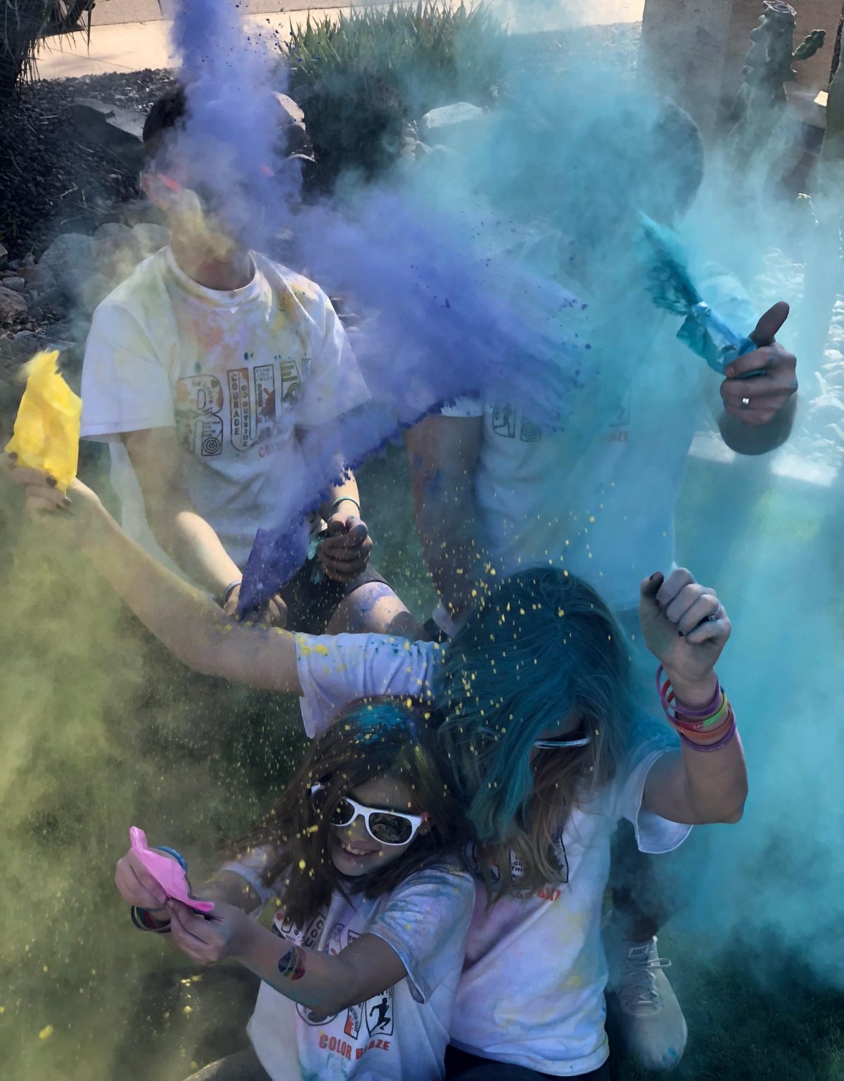 Group of kids flinging colored powder at each other in a color war