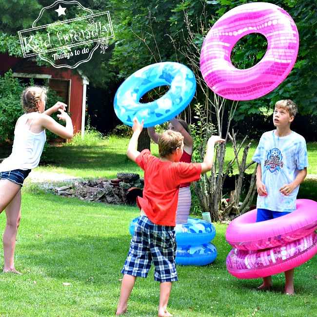 Students throw large inflatable rings at their partner, trying to get the ring around their partner's body.