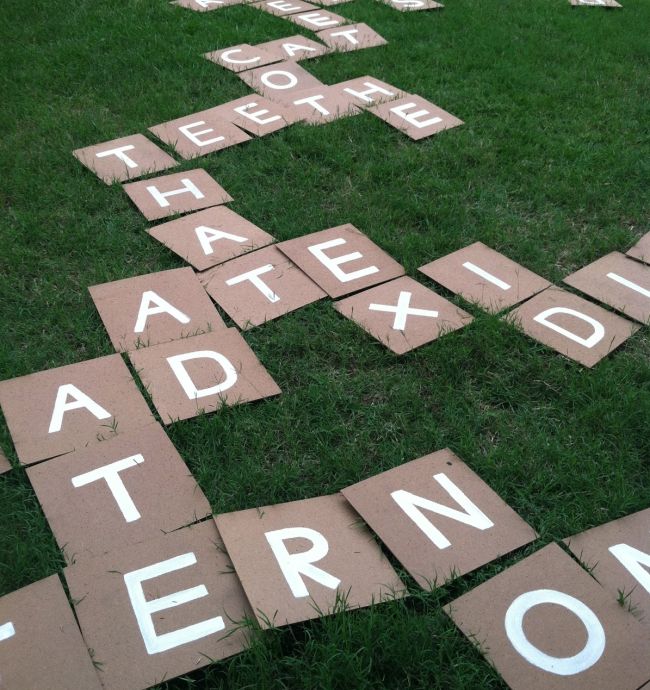 Large letter tiles laid out on grass to form words