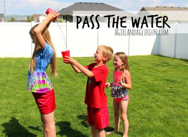 Kids pouring water from a cup over their head to the person behind