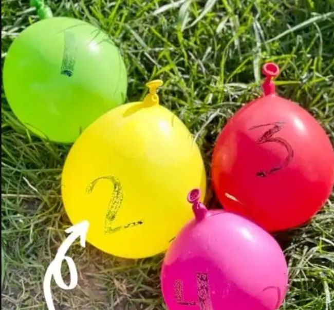 Colorful water balloons numbered 1 to 4 lying on the grass