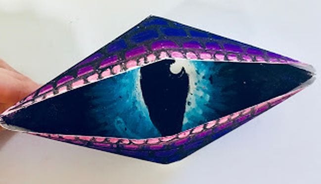 Purple paper eye folded out of paper and colored
