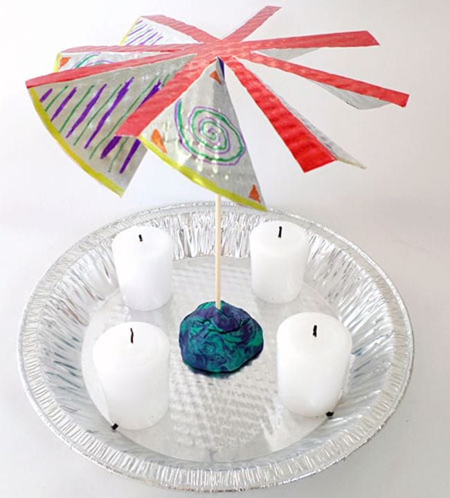 Pinwheel mounted over a tin plate with four candles underneath (Fifth Grade Science)